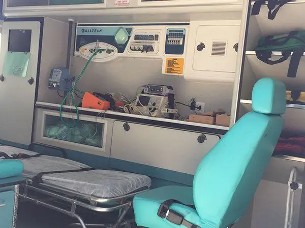 Interior da ambulância com cadeira e maca